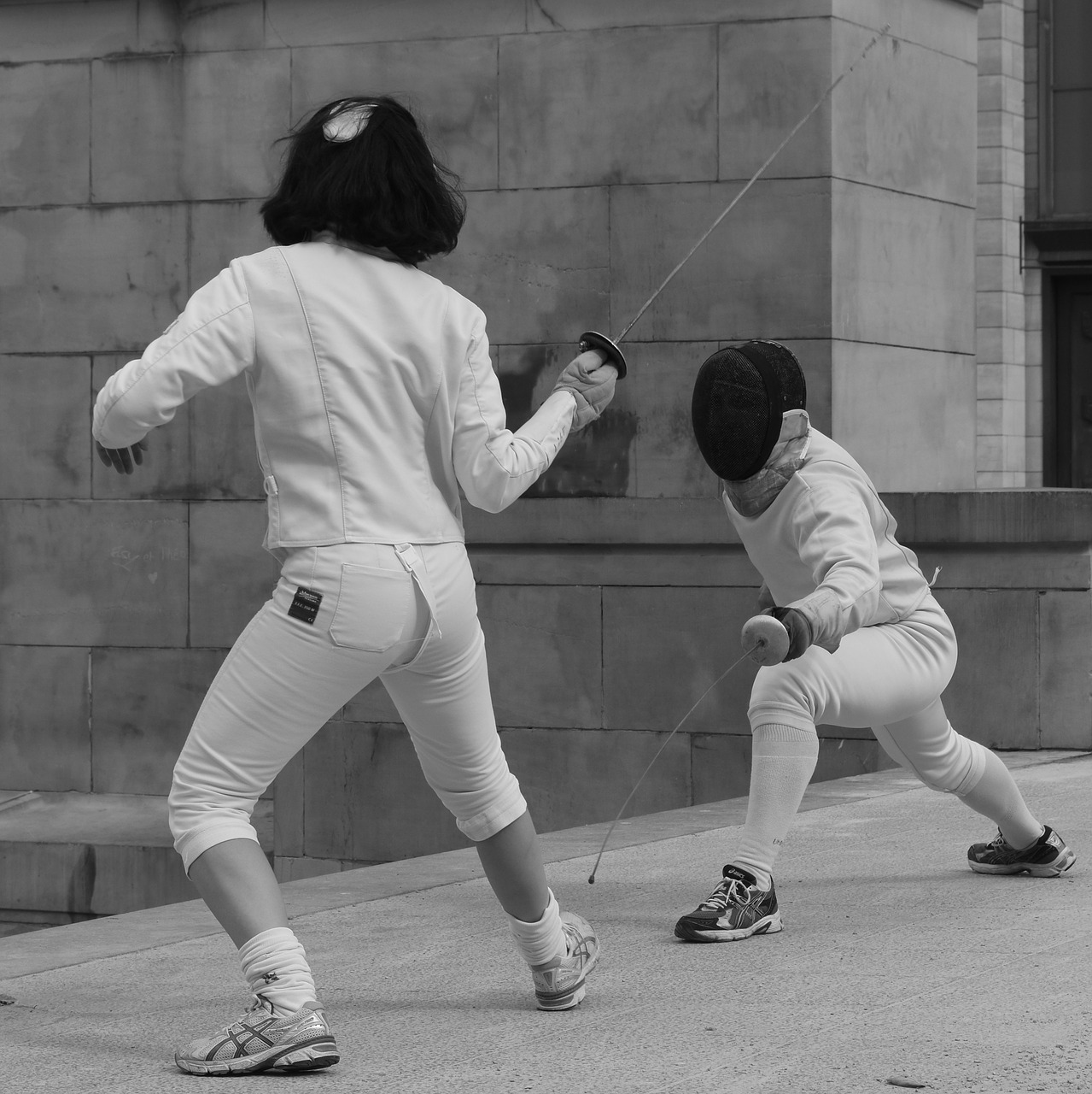 People fencing, one on the attack